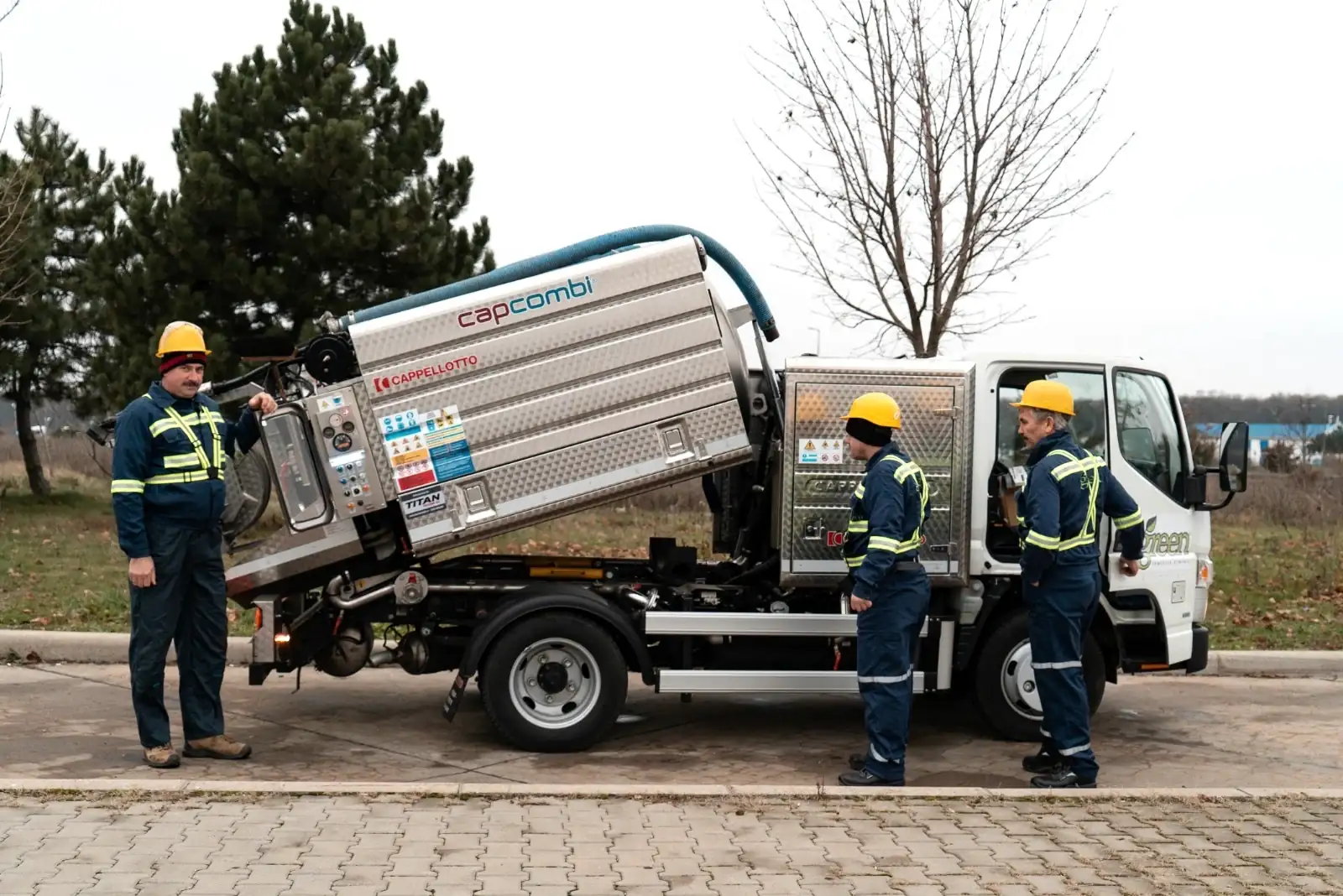 Autovidanja CAPPELLOTTO pe șasiu Mitsubishi FUSO Canter, cu cisterna ridicată și echipa lângă ea